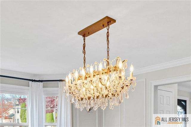 interior details featuring ornamental molding and an inviting chandelier