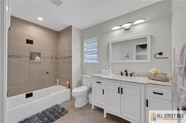 full bathroom featuring vanity, toilet, and tiled shower / bath