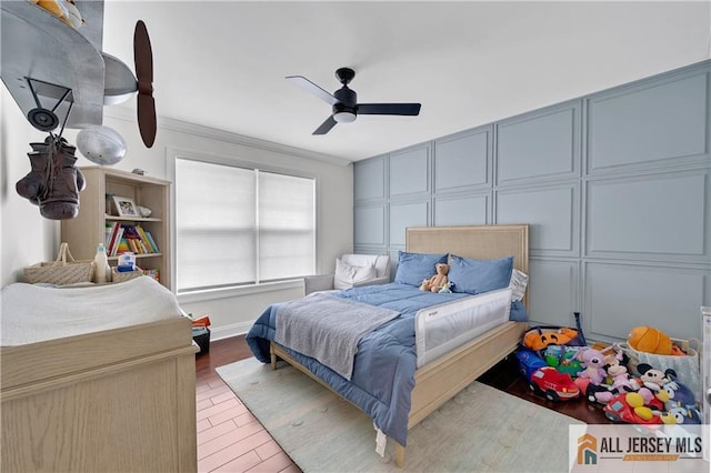 bedroom with hardwood / wood-style floors, ceiling fan, and crown molding