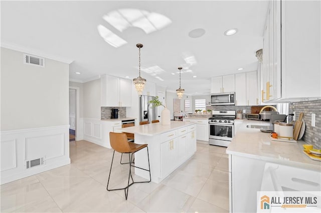 kitchen featuring sink, a center island, white cabinets, and appliances with stainless steel finishes