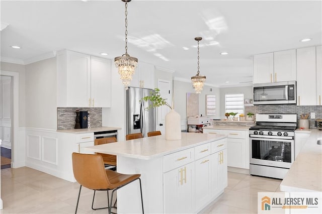 kitchen with decorative light fixtures, a center island, white cabinetry, and stainless steel appliances