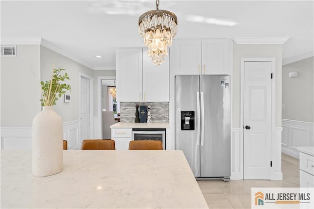 kitchen featuring stainless steel fridge with ice dispenser, white cabinetry, light stone counters, and pendant lighting