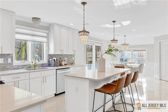 kitchen with white cabinets, dishwasher, sink, and a wealth of natural light