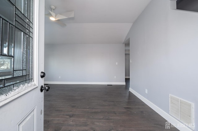 unfurnished room featuring vaulted ceiling, dark hardwood / wood-style floors, and ceiling fan