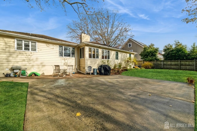 back of property featuring a patio and a lawn