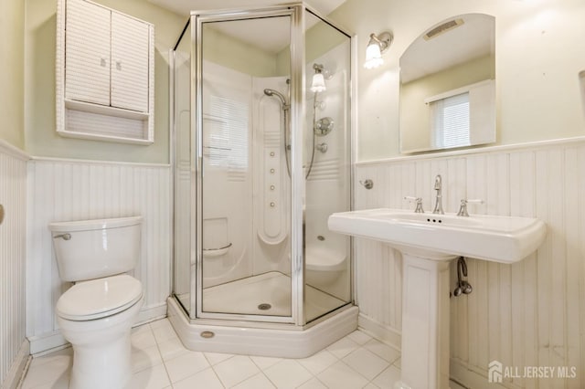 bathroom with tile patterned floors, toilet, a shower with shower door, and sink