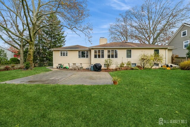 rear view of house featuring a yard and a patio