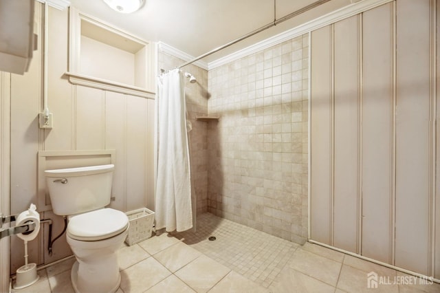 bathroom with a shower with shower curtain, tile patterned floors, and toilet