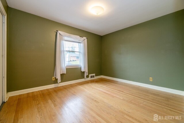 unfurnished room with hardwood / wood-style flooring