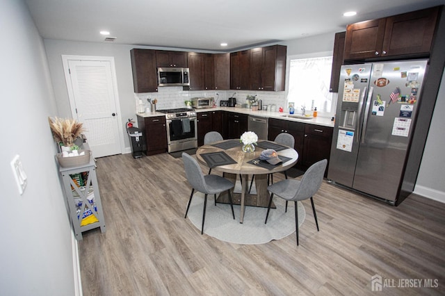 20 Prentice Ave, South River, NJ 08882 - kitchen with appliances with stainless steel finishes, light wood-style floors, dark brown cabinets, light countertops, and tasteful backsplash