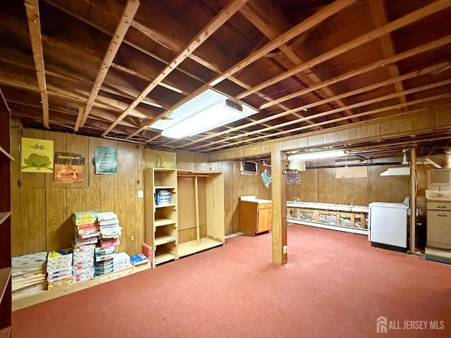 unfinished basement with washer / clothes dryer and wooden walls