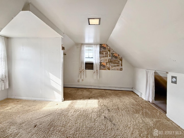 additional living space featuring a baseboard radiator, carpet floors, baseboards, and vaulted ceiling