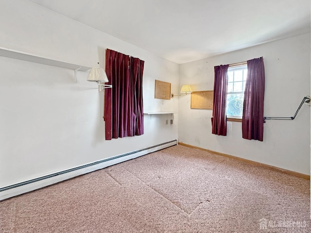 carpeted spare room featuring baseboard heating and baseboards