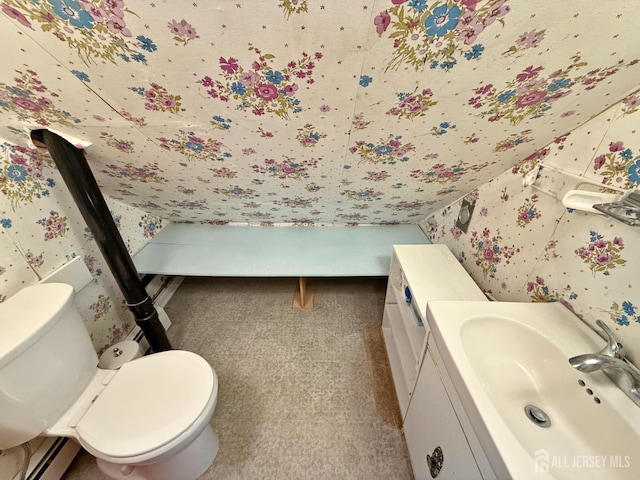 bathroom featuring toilet, wallpapered walls, baseboard heating, and vanity