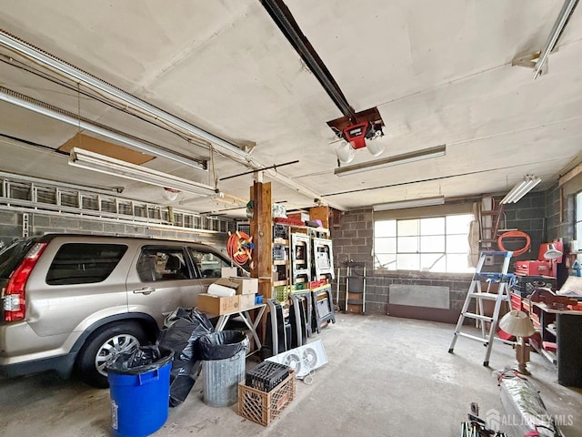 garage featuring a garage door opener and concrete block wall