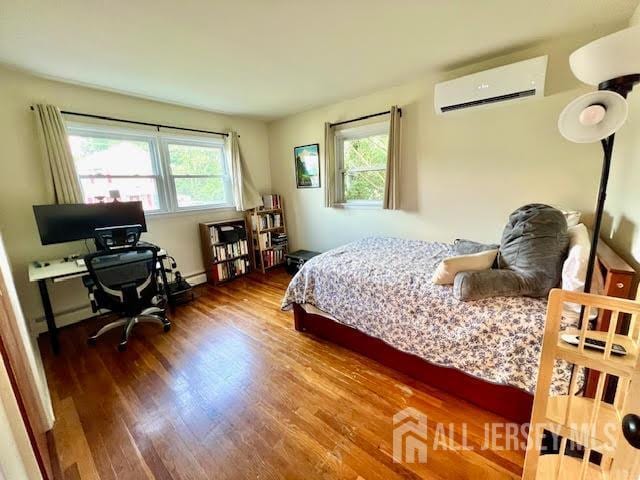 45 Browning Ave, Ewing, NJ 08638 - bedroom with an AC wall unit, multiple windows, and wood finished floors