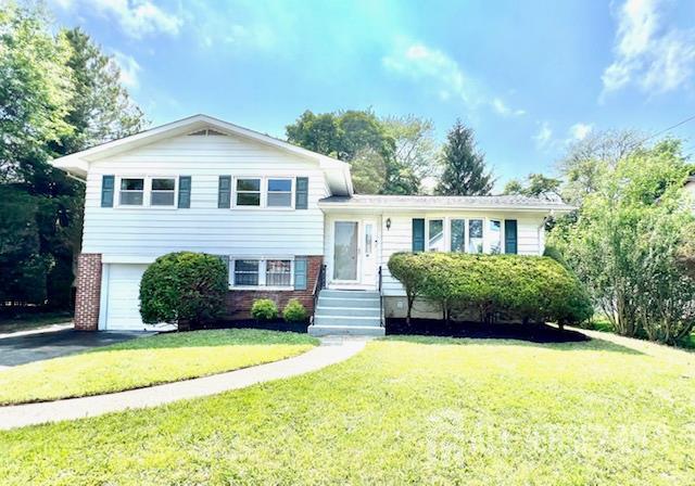 45 Browning Ave, Ewing, NJ 08638 - tri-level home with an attached garage, a front yard, brick siding, and asphalt driveway