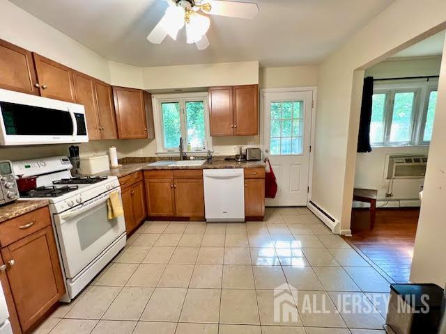 45 Browning Ave, Ewing, NJ 08638 - kitchen with white appliances, baseboard heating, brown cabinetry, and light tile patterned flooring