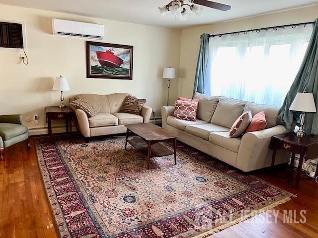 45 Browning Ave, Ewing, NJ 08638 - living area with an AC wall unit, wood finished floors, and a ceiling fan