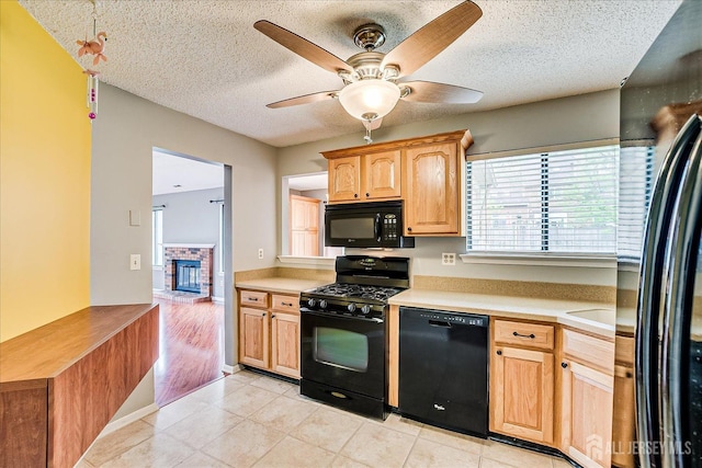 kitchen featuring light countertops, a textured ceiling, a ceiling fan, and black appliances