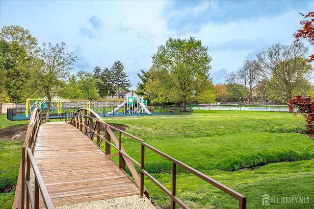 exterior space featuring a lawn, fence, and playground community