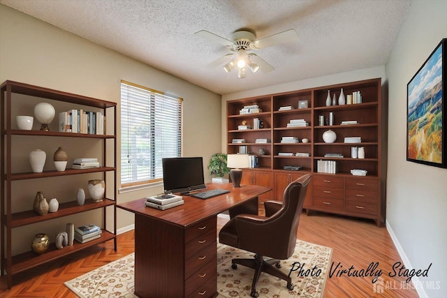 home office with baseboards, a ceiling fan, and a textured ceiling