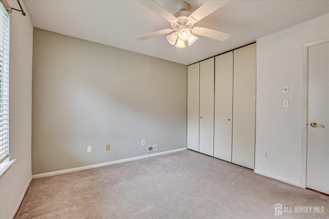 unfurnished bedroom with carpet floors, baseboards, and visible vents