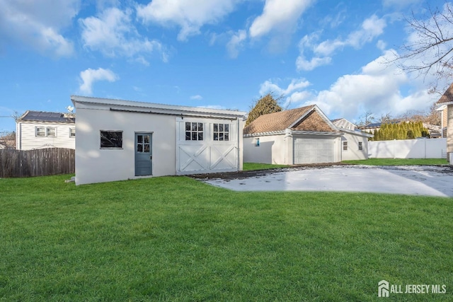 221 E Golf Ave, South Plainfield, NJ 07080 - rear view of house featuring stucco siding, an attached garage, an outdoor structure, and concrete driveway