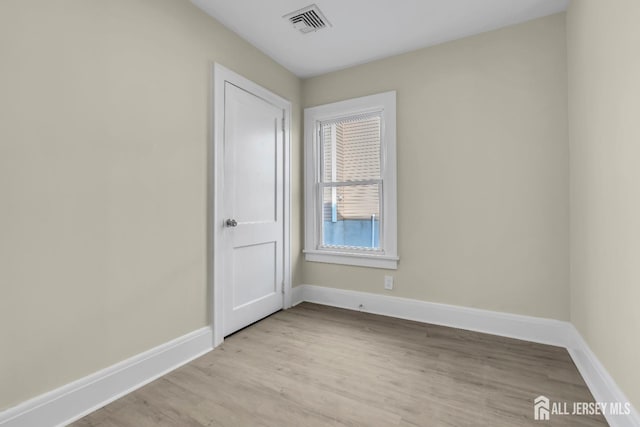 spare room with visible vents, light wood-style flooring, and baseboards
