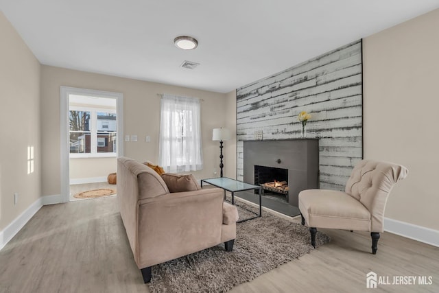 221 E Golf Ave, South Plainfield, NJ 07080 - living area with wood finished floors, a large fireplace, baseboards, and an accent wall