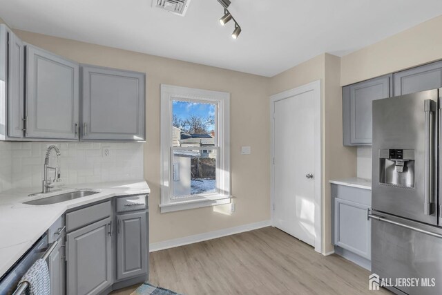 221 E Golf Ave, South Plainfield, NJ 07080 - kitchen with stainless steel appliances, gray cabinetry, a sink, light wood-style flooring, and light countertops