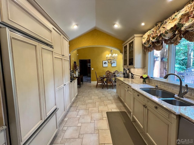2 Gloucester Ct, East Brunswick, NJ 08816 - kitchen featuring lofted ceiling, stone tile floors, a sink, a chandelier, and arched walkways
