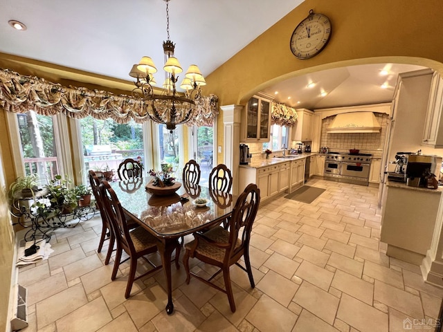 2 Gloucester Ct, East Brunswick, NJ 08816 - dining area with vaulted ceiling, stone tile floors, arched walkways, and a notable chandelier