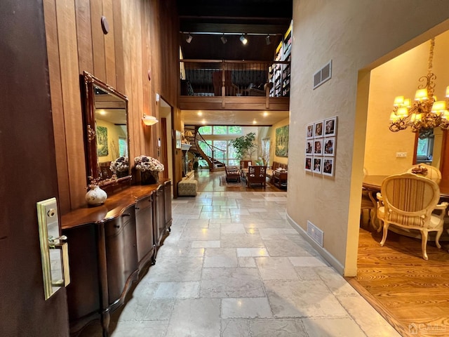 2 Gloucester Ct, East Brunswick, NJ 08816 - hall featuring a chandelier, a towering ceiling, visible vents, and stone tile flooring
