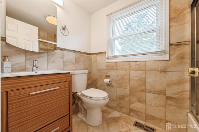 1 Webster Rd, Franklin, NJ 08873 - bathroom featuring vanity, toilet, tile walls, tile patterned flooring, and a wainscoted wall