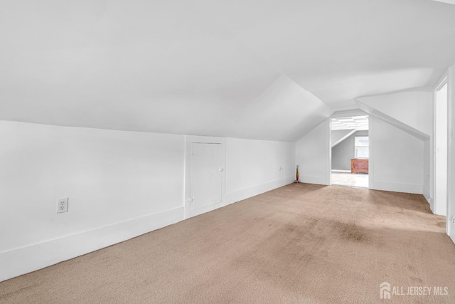 bonus room with vaulted ceiling, carpet flooring, and baseboards