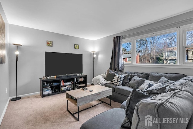 living area with light colored carpet, baseboards, and a wealth of natural light