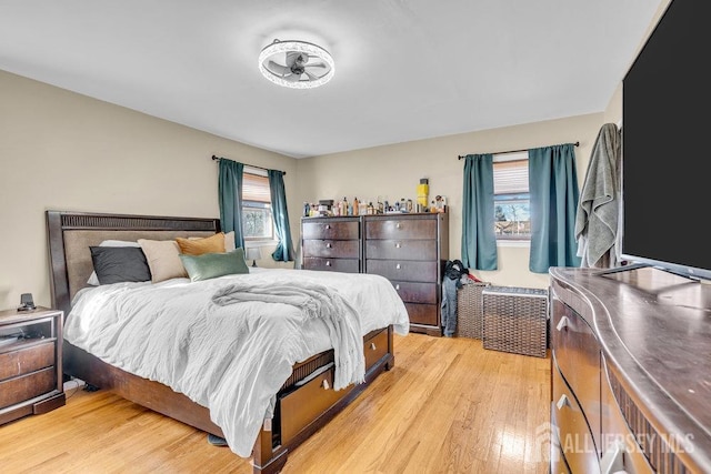 bedroom with multiple windows and light wood-type flooring