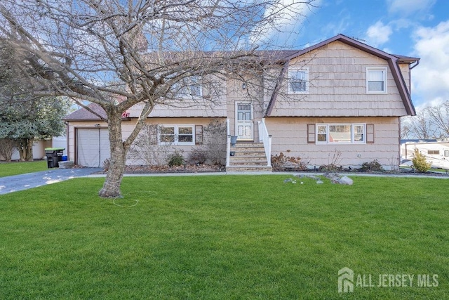 split foyer home featuring a garage, driveway, and a front lawn