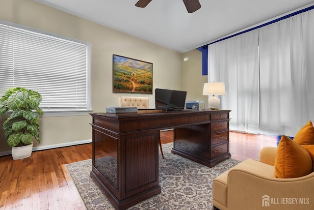 home office featuring baseboards, a ceiling fan, and hardwood / wood-style flooring