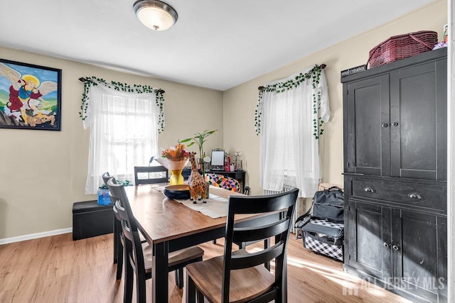 dining area featuring light wood-style flooring and baseboards