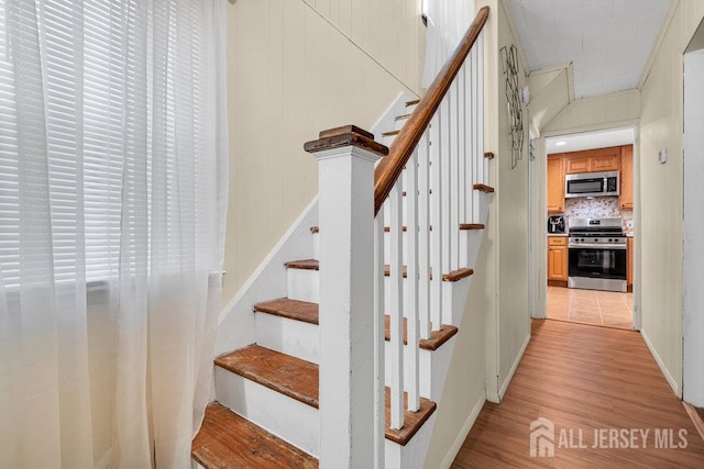 stairs featuring wood finished floors