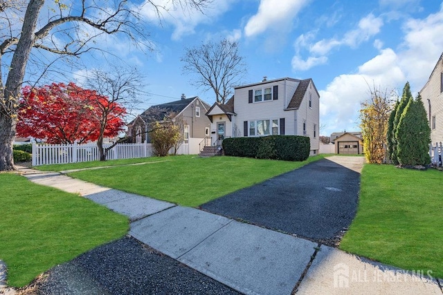 view of front of home with a garage, an outdoor structure, and a front lawn