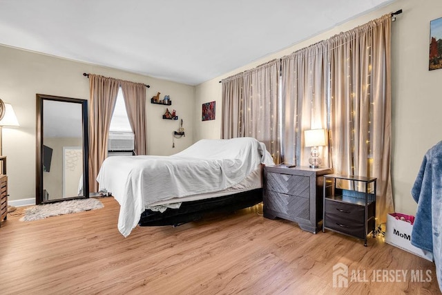 bedroom featuring light wood-style flooring and cooling unit