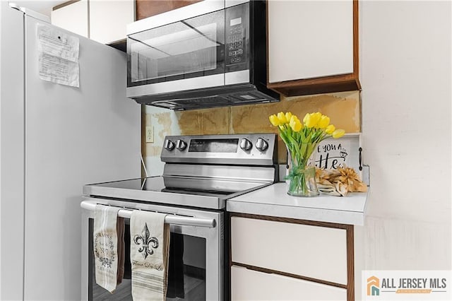 40 Haddon Rd Unit 40B, Monroe, NJ 08831 - kitchen featuring appliances with stainless steel finishes, backsplash, light countertops, and white cabinets