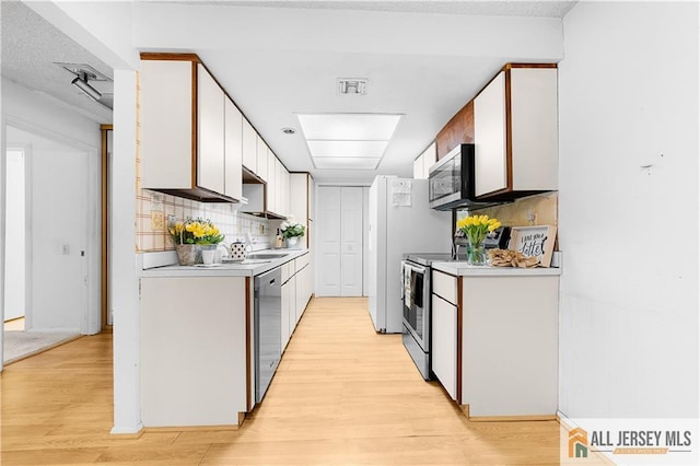40 Haddon Rd Unit 40B, Monroe, NJ 08831 - kitchen with appliances with stainless steel finishes, light wood-style floors, light countertops, and white cabinets