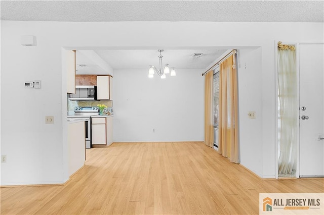 40 Haddon Rd Unit 40B, Monroe, NJ 08831 - kitchen with stainless steel appliances, light wood-style floors, a chandelier, tasteful backsplash, and white cabinetry