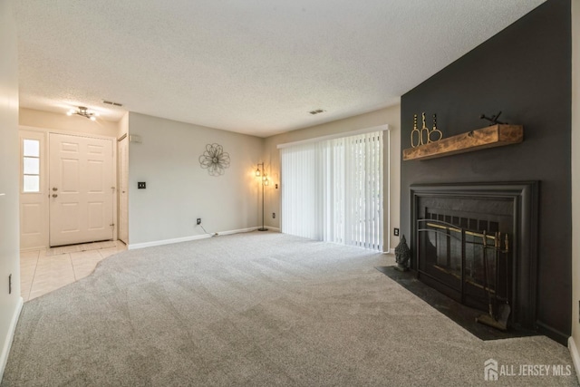 unfurnished living room with a healthy amount of sunlight, carpet floors, a fireplace, and a textured ceiling
