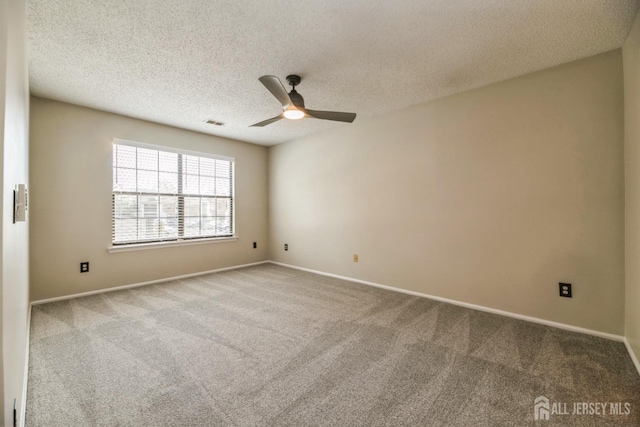 carpeted empty room with visible vents, a ceiling fan, a textured ceiling, and baseboards