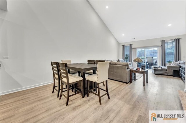 dining space featuring recessed lighting, light wood-style flooring, and high vaulted ceiling